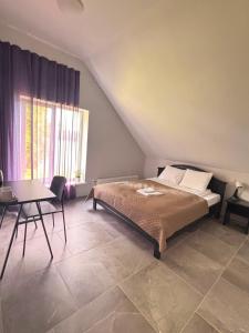 a bedroom with a bed and a table and a window at Orinoko Guest House in Stacija Sece +50 photos