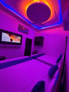 a room with purple lights and a tv at MShotel Surajgarh in Sūrajgarh +24 photos