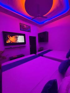 a living room with pink lights and a tv at MShotel Surajgarh in Sūrajgarh