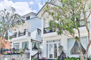 a white house with trees in front of it at villa Trung Nghĩa 5 in Da Lat