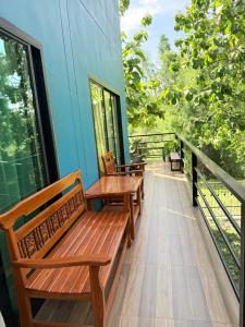 a porch with benches and a table on a balcony at Alit House in Phra Nakhon Si Ayutthaya