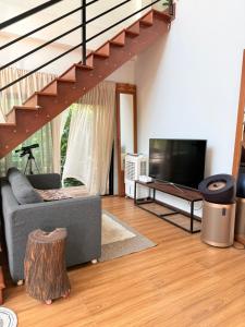 a living room with a couch and a flat screen tv at Alit House in Phra Nakhon Si Ayutthaya