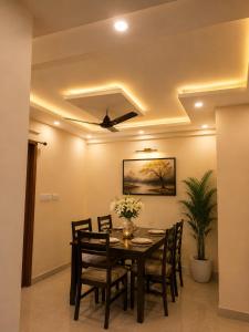 a dining room with a table and chairs and a ceiling at Flying Suites Newtown in kolkata