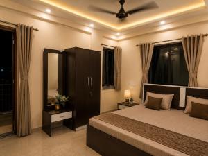 a bedroom with a bed and a ceiling fan at Flying Suites Newtown in kolkata