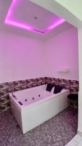 a purple room with a tub with a purple ceiling at Maison d'hôte okpèyèmi in Porto-Novo +84 photos