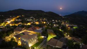a town at night with the moon in the sky at Dervisia Stonehouse 4 in Lazaráta