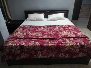 a bed with a red blanket and pillows on it at YVs Hungry island in Bāpatla
