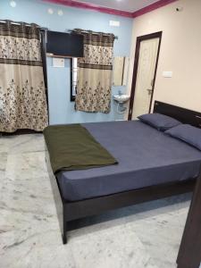 a bedroom with a bed in a room with curtains at YVs Hungry island in Bāpatla
