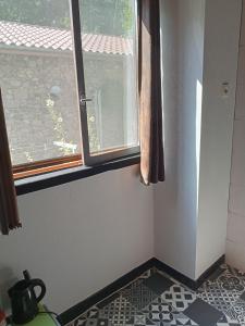 a bathroom with a window and a tiled floor at Le repaire des écureuils in Bourg-Argental