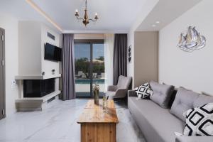 a living room with a couch and a table at Athena Villas in Vasilikos