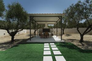 a pavilion with a table and chairs on a lawn at Athena Villas in Vasilikos
