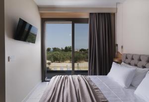 a bedroom with a bed and a large window at Athena Villas in Vasilikos +17 photos