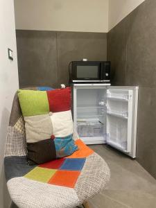 a couch with a colorful pillow sitting next to an open refrigerator at Masseria Frangiosa in Torrecuso