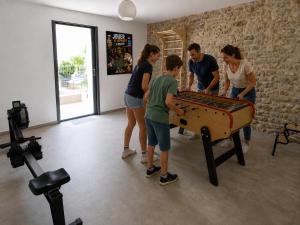 a group of people standing around a ping pong table at La Grange de Junas in Junas