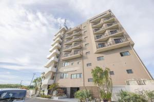 a tall building with trees in front of it at JUN Resort Hotel-CB0105 in Sanmu