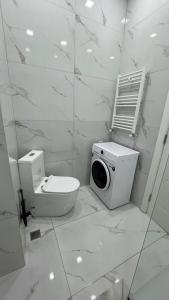 a white bathroom with a toilet and a microwave at 21 floor apartment in Tbilisi City