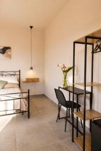 a bedroom with a bed and a table and chairs at Eterea Dimora Sul Fiume in Noto