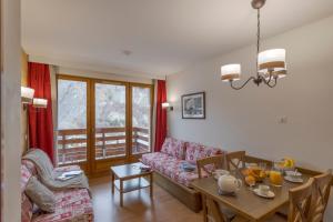 a living room with a couch and a table at Résidence Goélia Les Chalets Valoria in Valloire
