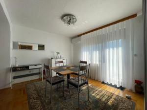 a dining room with a table and chairs at Restful Garden Apartmants in Sarajevo