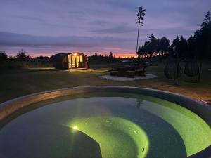 a large pool of water in front of a yurt at Log Off Männivälja forest cabins in Odulemma
