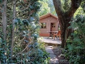 a small wooden cabin with a table and a tree at FeWo Waldblick in Salzhemmendorf