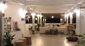a living room with white couches and plants in it at Samunthitar Resort in Khao Kho
