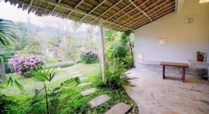 a patio with a bench and a view of a garden at Samunthitar Resort in Khao Kho