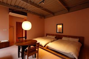 two beds in a room with a table and a tableasteryasteryasteryasteryastery at たゆら in Nara