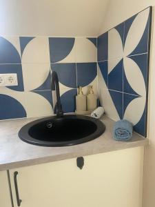 a sink in a bathroom with blue and white tiles at Hello Apartman in Budaörs +52 photos