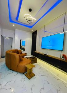 a living room with a couch and a flat screen tv at Flexxy Apartment Hotel in Oshogbo +10 photos