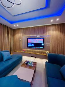 a living room with a couch and a tv at Flexxy Apartment Hotel in Oshogbo