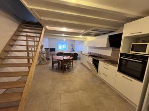 a kitchen and dining room with a table and a staircase at Maison 2 chambres 