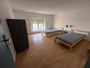 an empty room with two beds and a window at Maison 2 chambres 