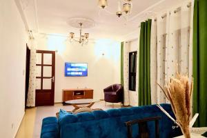 a living room with a blue couch and a table at Bj House in Douala