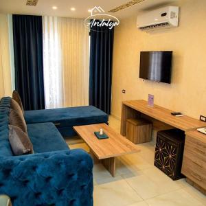 a living room with a blue couch and a television at Antalya Hotel Am in Amman