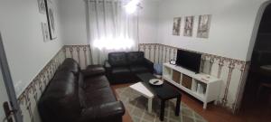 a living room with a couch and a television at Casa Viela in Viseu +12 photos