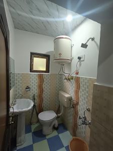 a small bathroom with a toilet and a sink at Alamdar guest house in Srinagar +89 photos