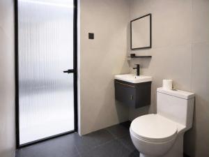 a bathroom with a toilet and a sink and a mirror at Lunan Boutique Hotel & Hostel in Taytay