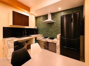 a kitchen with a black refrigerator and a table at Lunan Boutique Hotel & Hostel in Taytay