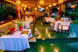 a restaurant with tables and chairs and a swimming pool at Shose Farmhouse Chalets & Campsite in Moshi