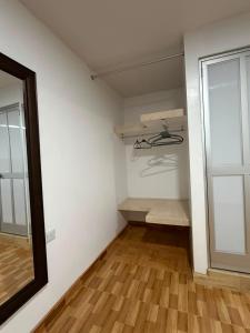 a walk in closet with white walls and wooden floors at La Casita de Merme in Oxapampa