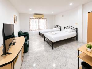 a room with two beds and a flat screen tv at Luxury Hotel ลักเซอรี่ โฮเทล in Ban Don Rak