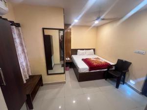 a small bedroom with a bed and a mirror at Hotel Royal Palace in Kolkata +7 photos