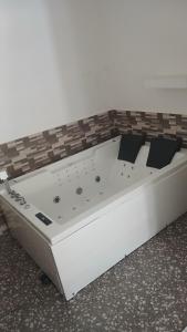 a white bed sitting on the floor in a room at Studio de luxe avec jacuzzi in Porto-Novo +34 photos