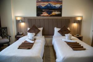 two beds in a hotel room with towels on them at Antalya Hotel Am in Amman