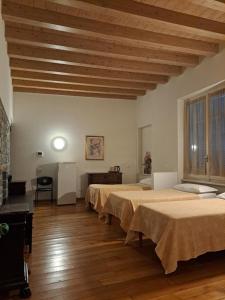 ein Zimmer mit vier Betten und einer Holzdecke in der Unterkunft Hotel Tre Re in Como