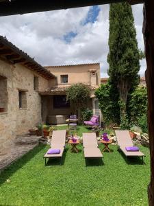 a yard with chairs and tables and a house at La Casona de Castilnovo - Gay Men Only in Valdesaz