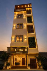 a tall building with a sign in front of it at HOTEL GILL TOWER (GRAND) in Hanumāngarh