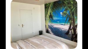 a bedroom with a picture of palm trees on the wall at Zenitude in Goumoens-la-Ville