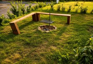 a wooden bench in the middle of the grass at Wellness chalupa in Havlíčkŭv Brod